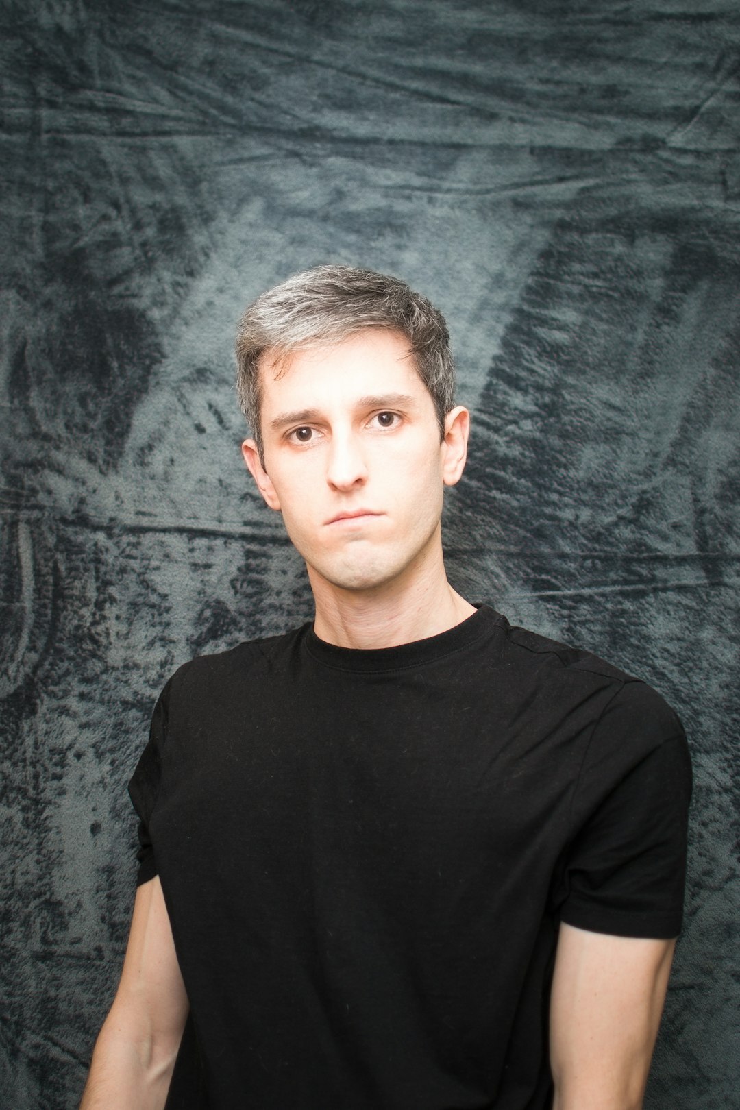 Studio portrait of a middle-aged man with short grey hair