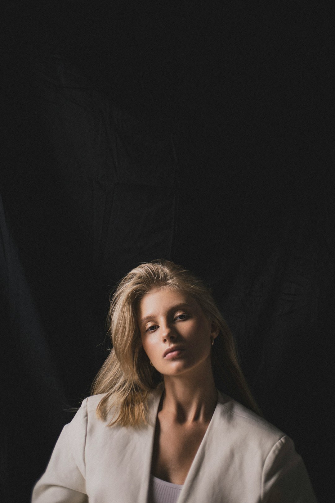 Studio portrait of a woman with blonde hair and a blazer